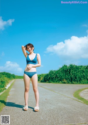 A woman in a red bikini standing in the water.