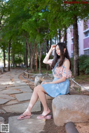 A woman in a blue skirt is posing for a picture.