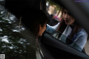 A couple of women sitting in the back seat of a car.