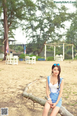 A woman in a blue and white outfit holding a red balloon.