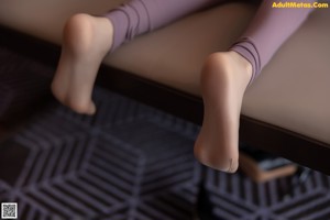A close up of a doll's legs on a bed.