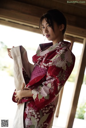 A woman in a kimono sitting in front of a mirror.