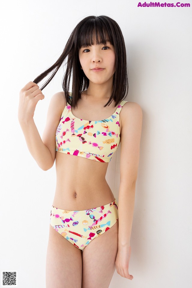 A young woman in a bikini top and panties posing for a picture.