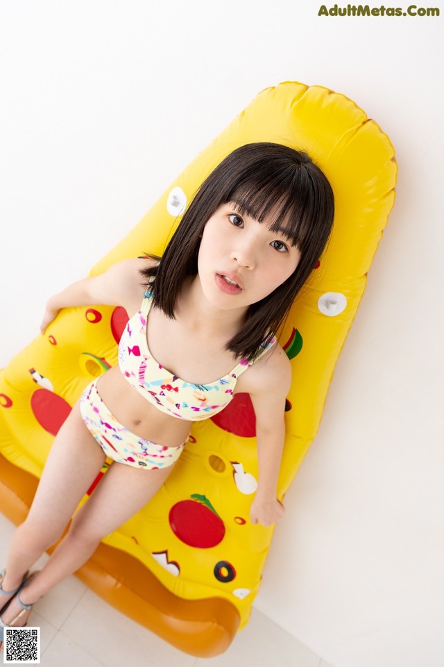 A woman in a bikini laying on an inflatable pizza.