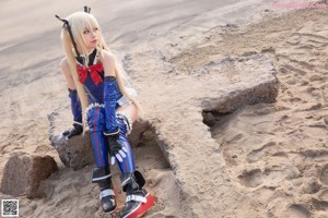 A woman in a blue and red outfit on a beach.