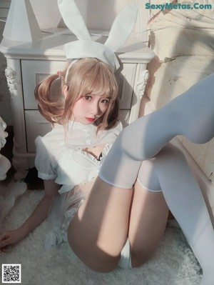 A woman in a white bunny costume posing for a picture.