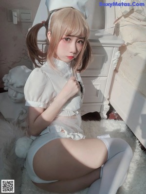 A woman in a bunny costume sitting on a toilet.