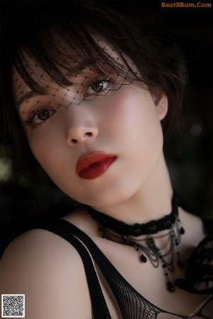 A woman in a black fishnet bodysuit is posing for the camera.