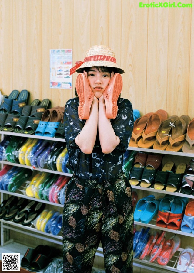 A woman standing in front of a rack of shoes.