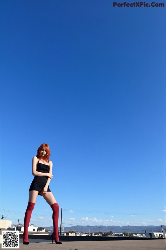 A woman in a black dress and red stockings posing for a picture.