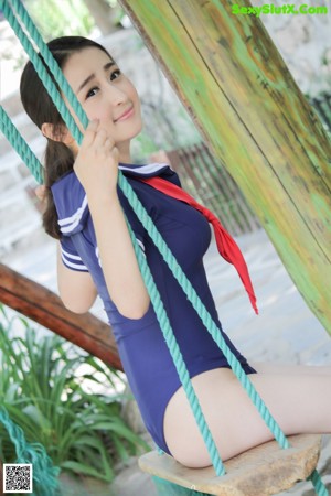 A woman in a blue and red bathing suit on a swing.