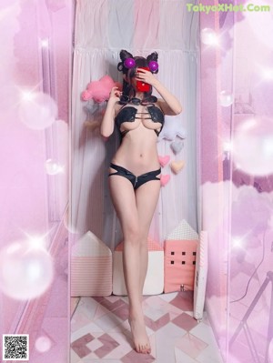 A woman in a black lingerie holding a pair of sunglasses.