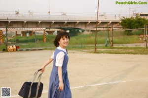 A woman in a blue dress is posing for a picture.