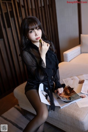 A woman sitting on top of a wooden table.