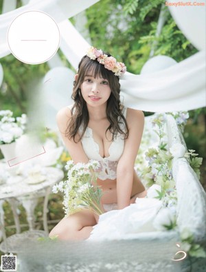 A woman in a white lingerie holding a white teddy bear.