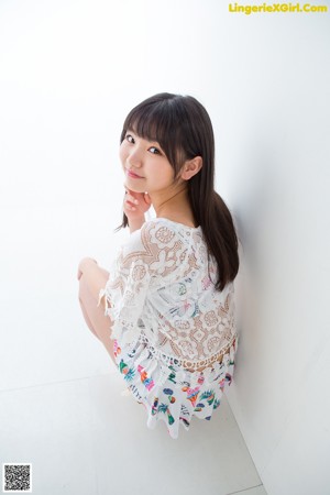 A woman in a white top and shorts posing for a picture.