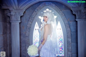 A woman in a wedding dress holding a bouquet of flowers.