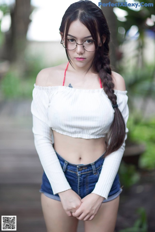 A woman wearing glasses and a white top posing for a picture.