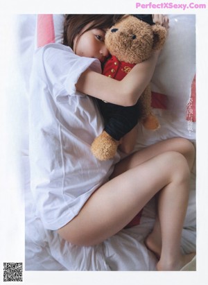 A woman laying in bed with her hand on her chin.