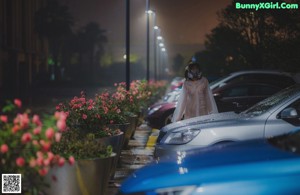 A woman standing in the middle of a street at night.