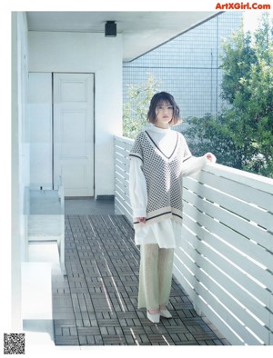 A woman sitting on top of a bathtub in a bathroom.