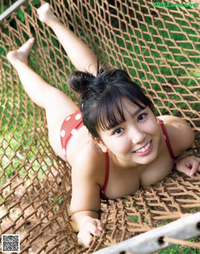 A woman in a red bikini laying in a hammock.